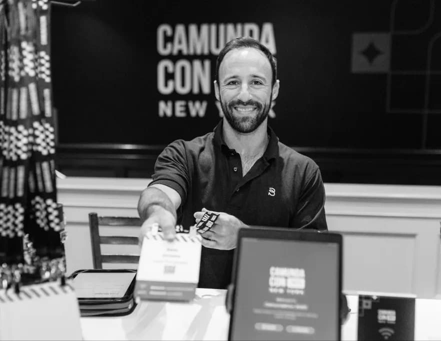 A CamundaCon attendee smiling at a Camunda stand